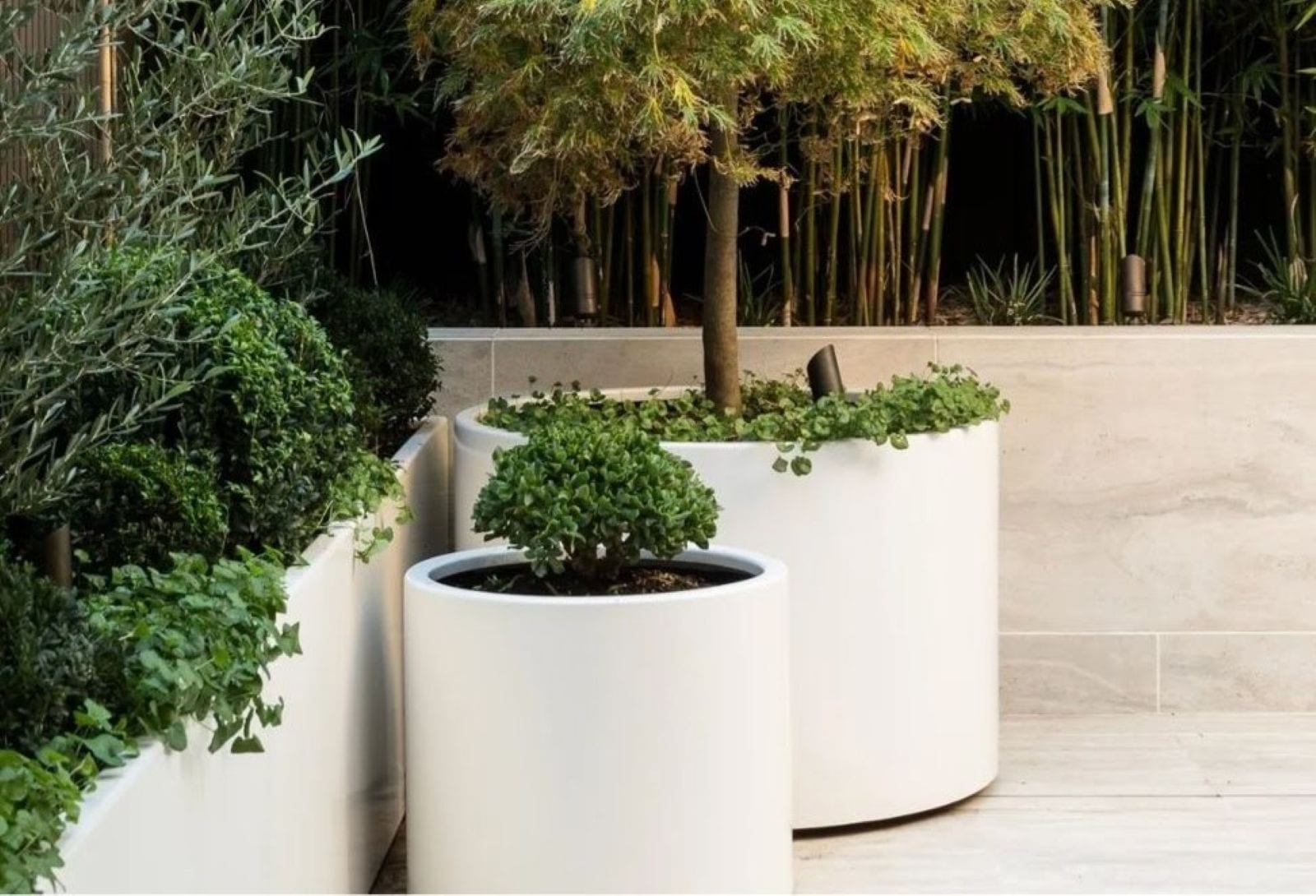 Cluster of aluminium cylinder planters in varied heights