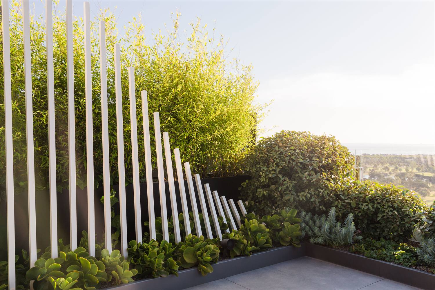 Aluminium landscape planter standing on a paved terrace corner